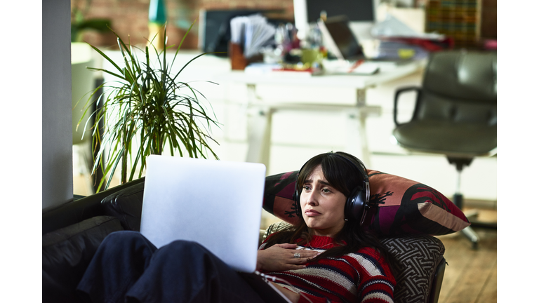 Emotional young woman using laptop and looking upset