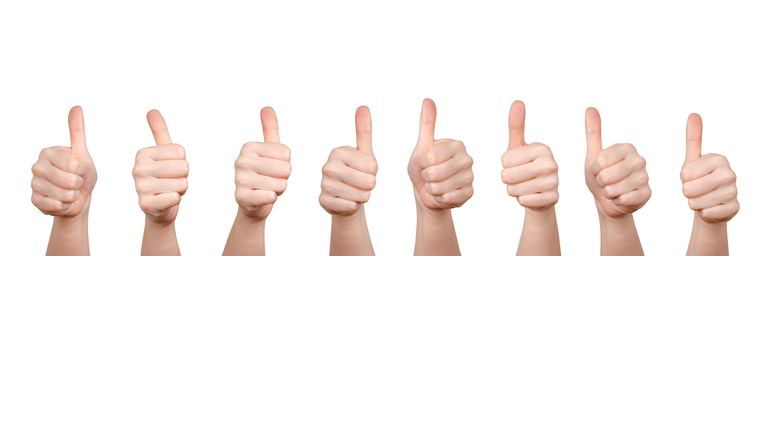 Panoramic View Of Cropped Hands Showing Thumbs Up Sign Against White Background