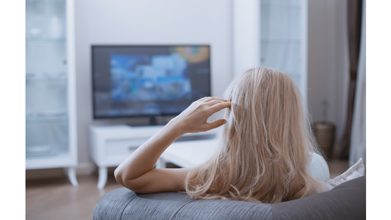 Woman watching TV in living room