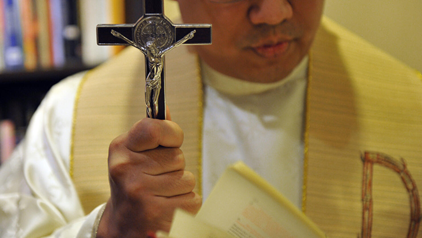Father Jose Francisco Syquia, head of the Manila Archdiocese's Office of Exorcism, prays at his office