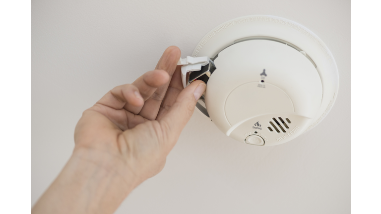 USA, New Jersey, Jersey City, Hand changing battery in smoke alarm