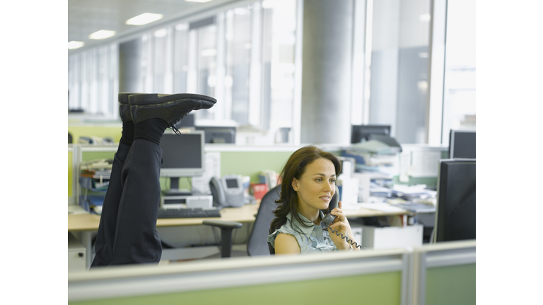 Businessman doing headstand in office