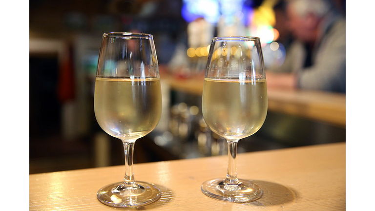 Two glasses of white wine in a bar.