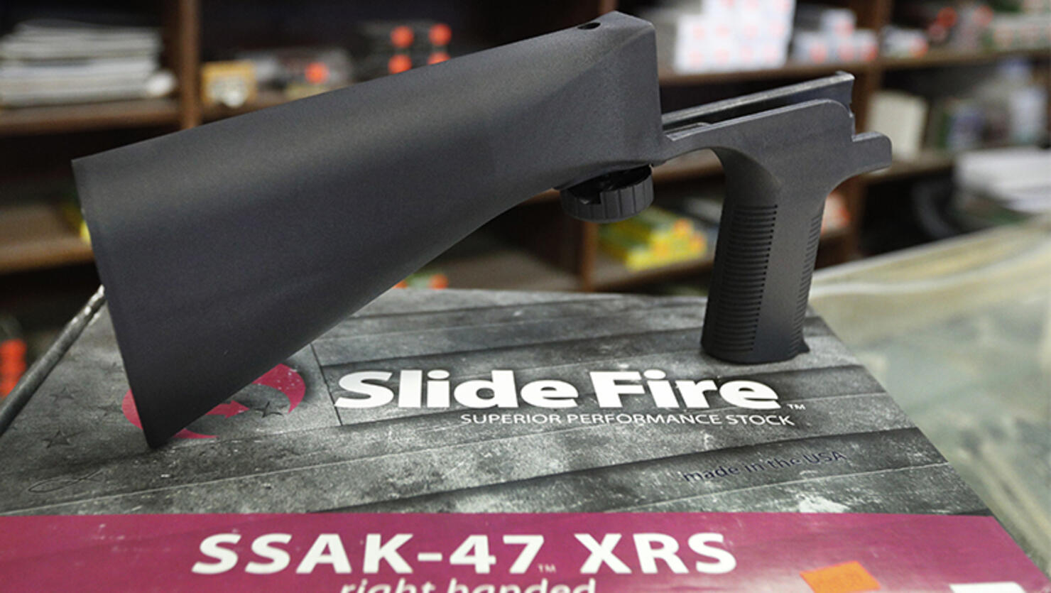A bump stock device, made by Slide Fire, that fits on a semi-automatic rifle to increase the firing speed, making it similar to a fully automatic rifle, sits on it's packaging at a gun store 