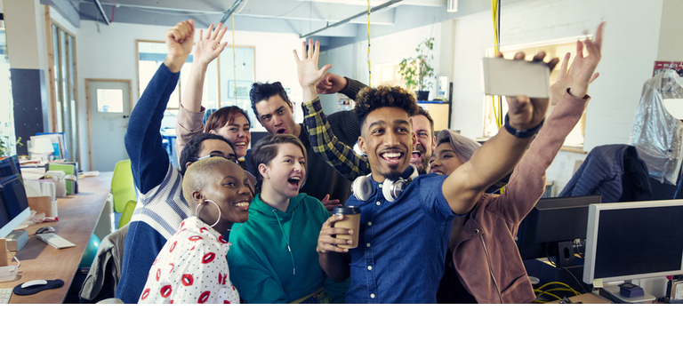 Enthusiastic creative business team taking selfie in office