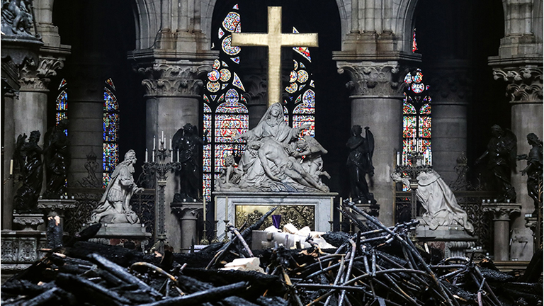 A picture taken on April 16, 2019 shows the altar surrounded by charred debris inside the Notre-Dame Cathedral in Paris in the aftermath of a fire that devastated the cathedral. - French investigators probing the devastating blaze at Notre-Dame 