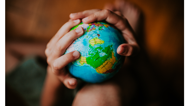 Child holding a globe/ Catherine Falls Commercial/Getty Images