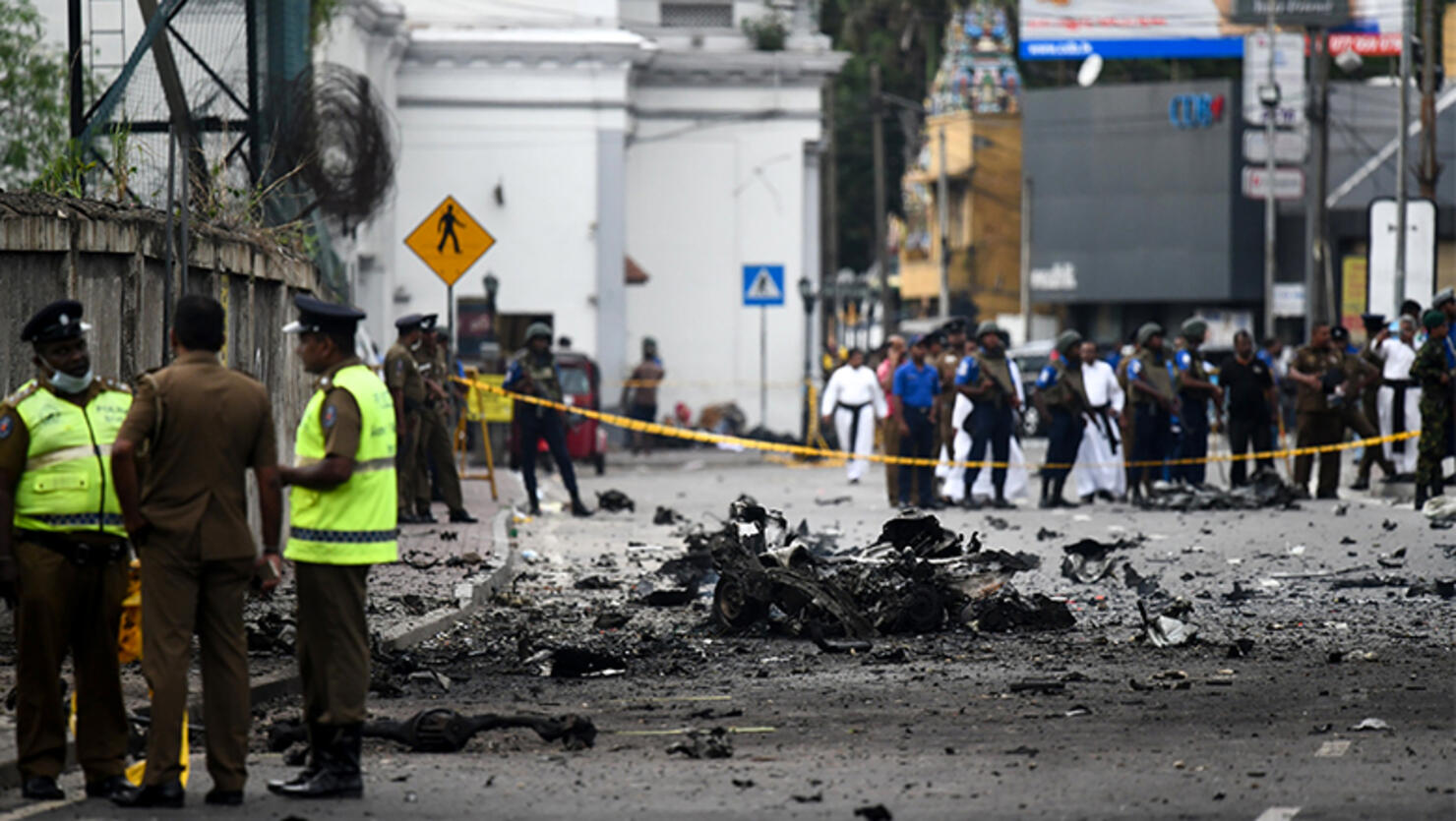 Sri Lankan security personnel inspect the debris of a car after it explodes when police tried to defuse a bomb near St. Anthony's Shrine in Colombo on April 22, 2019, a day after the series of bomb blasts targeting churches and luxury hotels in Sri Lanka.