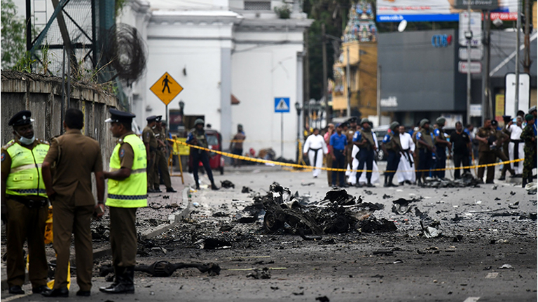 Sri Lankan security personnel inspect the debris of a car after it explodes when police tried to defuse a bomb near St. Anthony's Shrine in Colombo on April 22, 2019, a day after the series of bomb blasts targeting churches and luxury hotels in Sri Lanka.