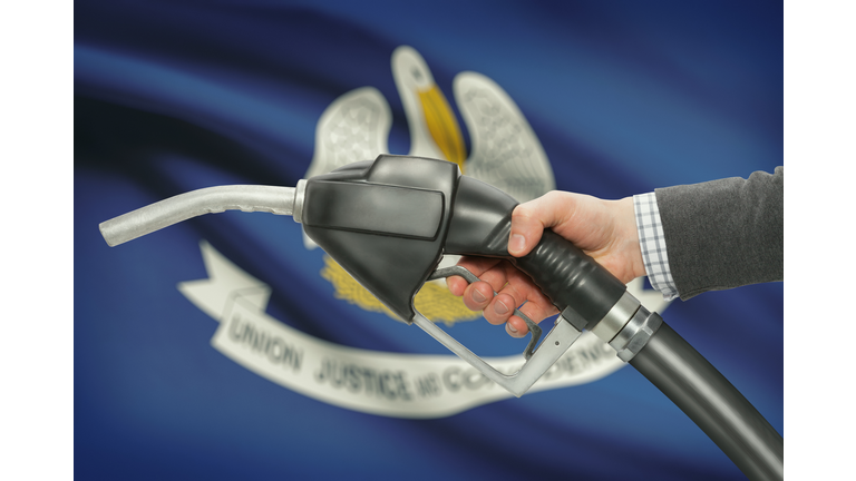 Fuel pump nozzle in hand with USA states flags on background - Louisiana