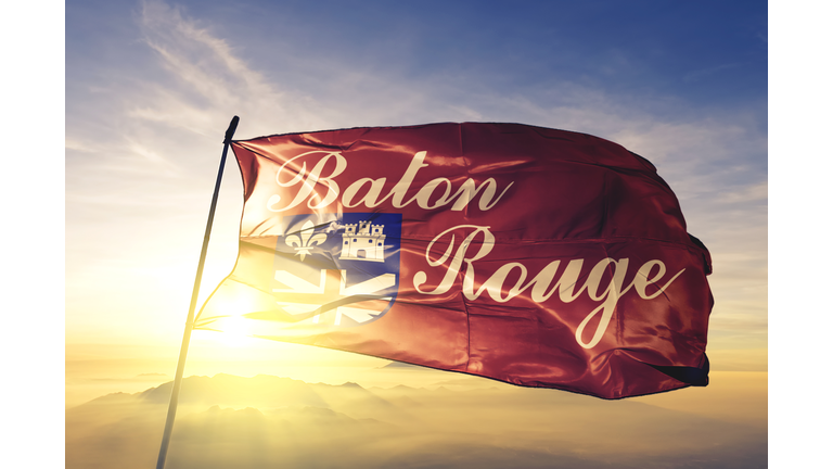 Baton Rouge city capital of Louisiana of United States flag textile cloth fabric waving on the top sunrise mist fog