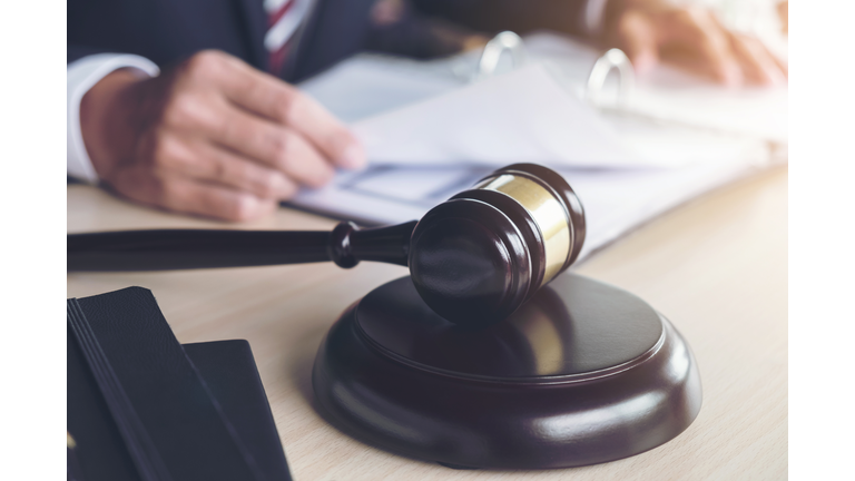 Cropped Hands Of Judge By Gravel At Table