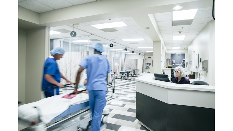 Doctors pushing patient in hospital gurney