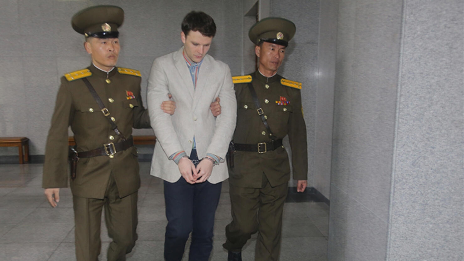 American student Otto Frederick Warmbier, center, arrives at a court for his trial in Pyongyang, capital of the Democratic People's Republic of Korea