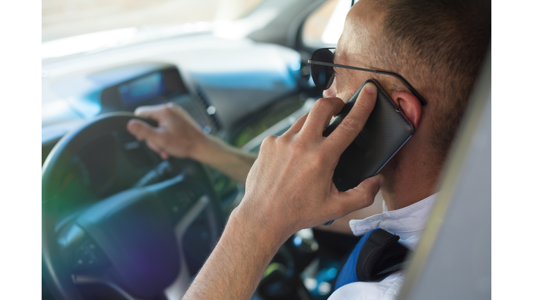 Man using smart phone in car