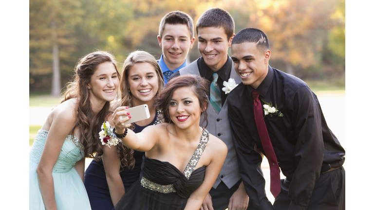 Teenagers taking selfie with cell phone before prom