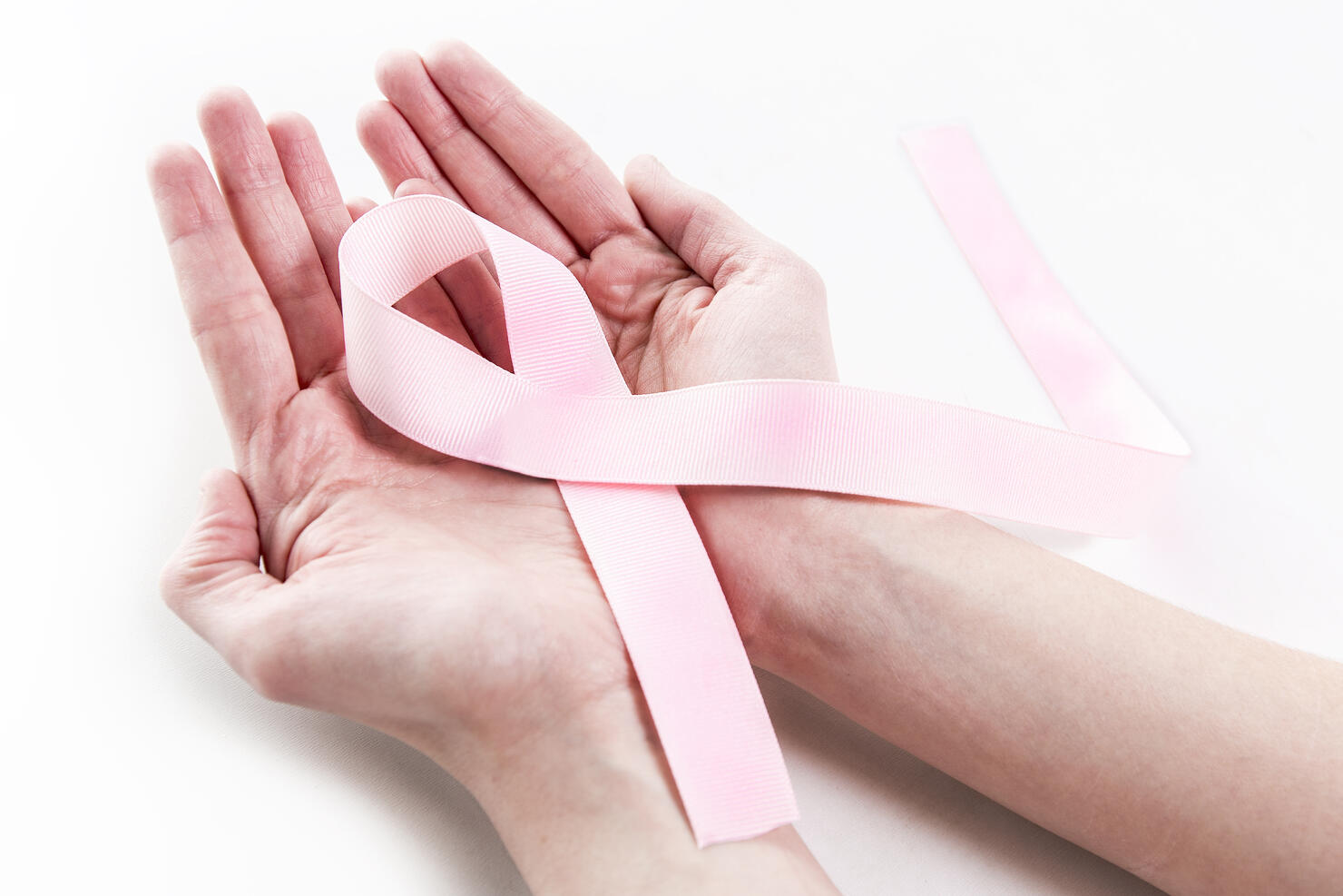 Closeup Old woman hand holding pink ribbon on white background ,Awareness breast cancer concept