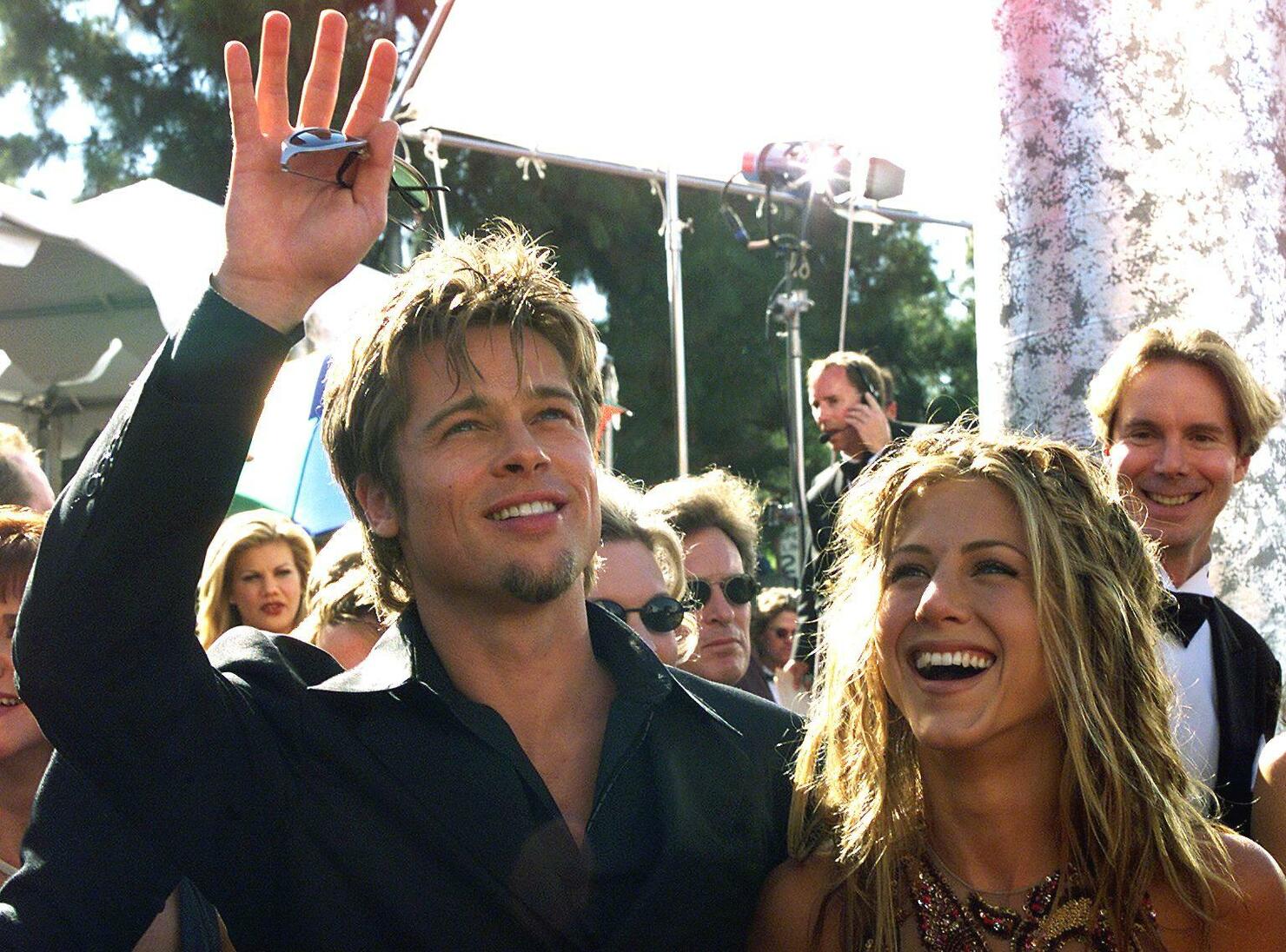 Actor Brad Pitt (L) waves to spectators as he arri