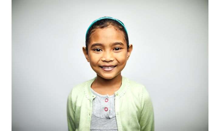 Portrait of cute girl smiling on white background