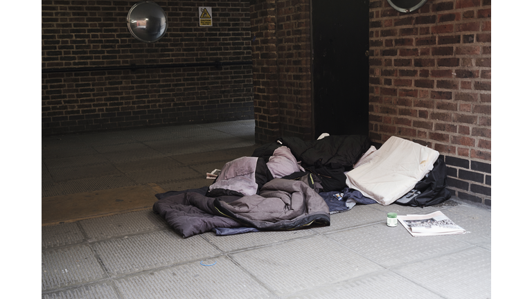 High angle view of sleeping bag on footpath by brick wall in city