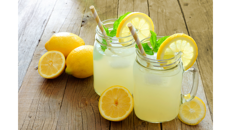 Mason jar glasses of homemade lemonade on rustic wood