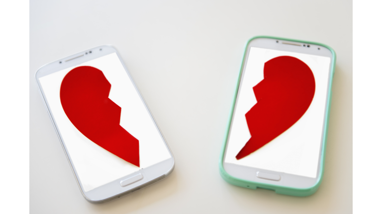 Studio shot of smart phones with broken heart on screen