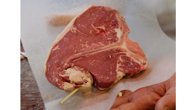 A butcher displays a finished cut of prime