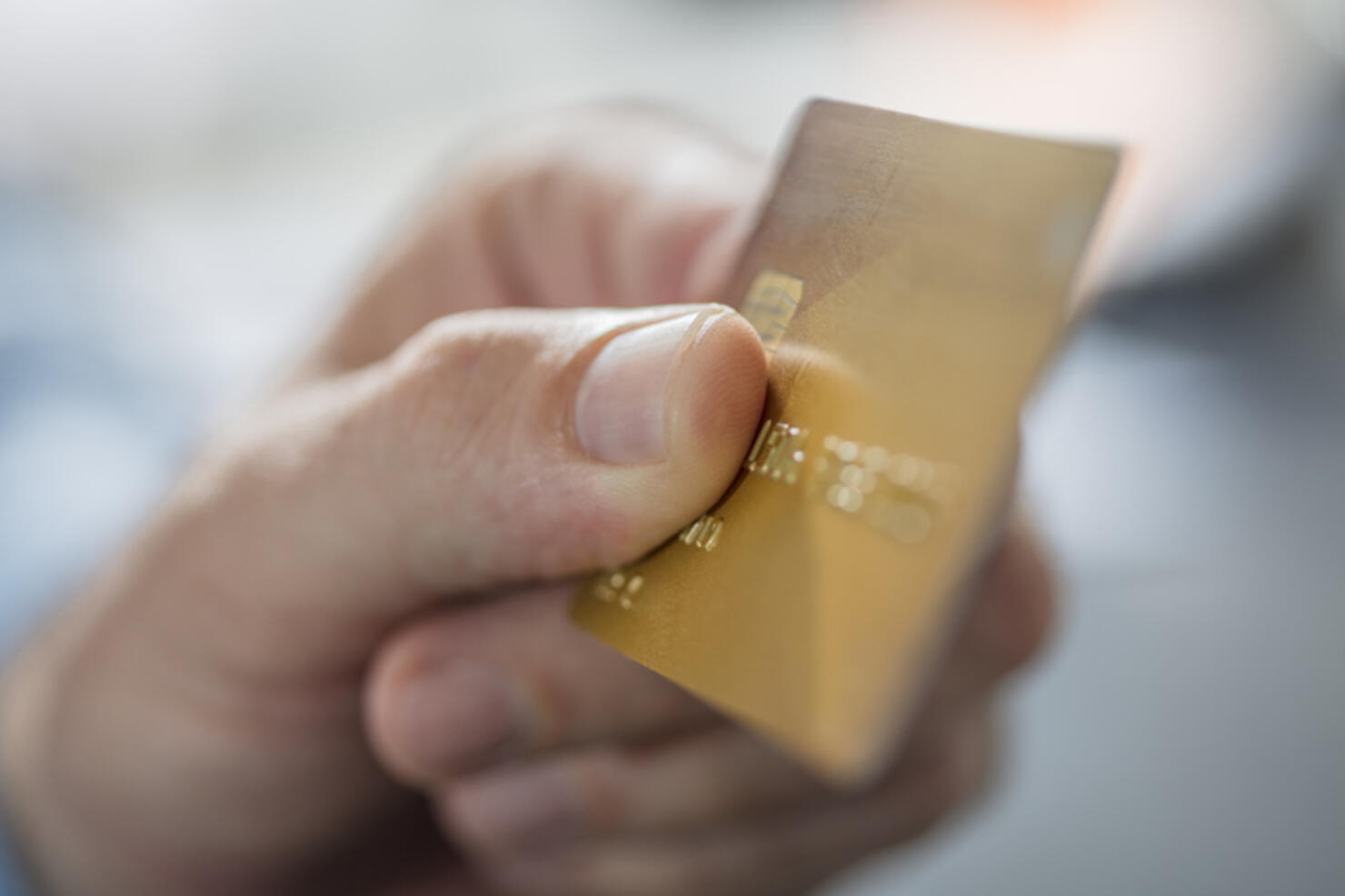 Man's hand holding credit card, close-up