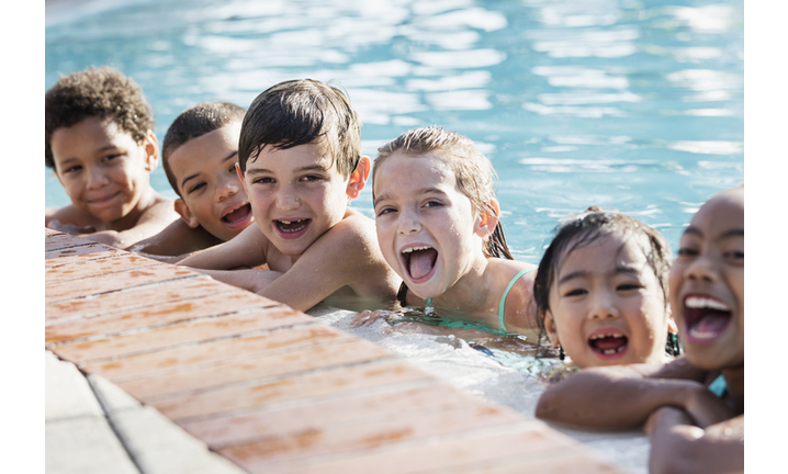 Multi-ethnic group of children on side of swimming pool