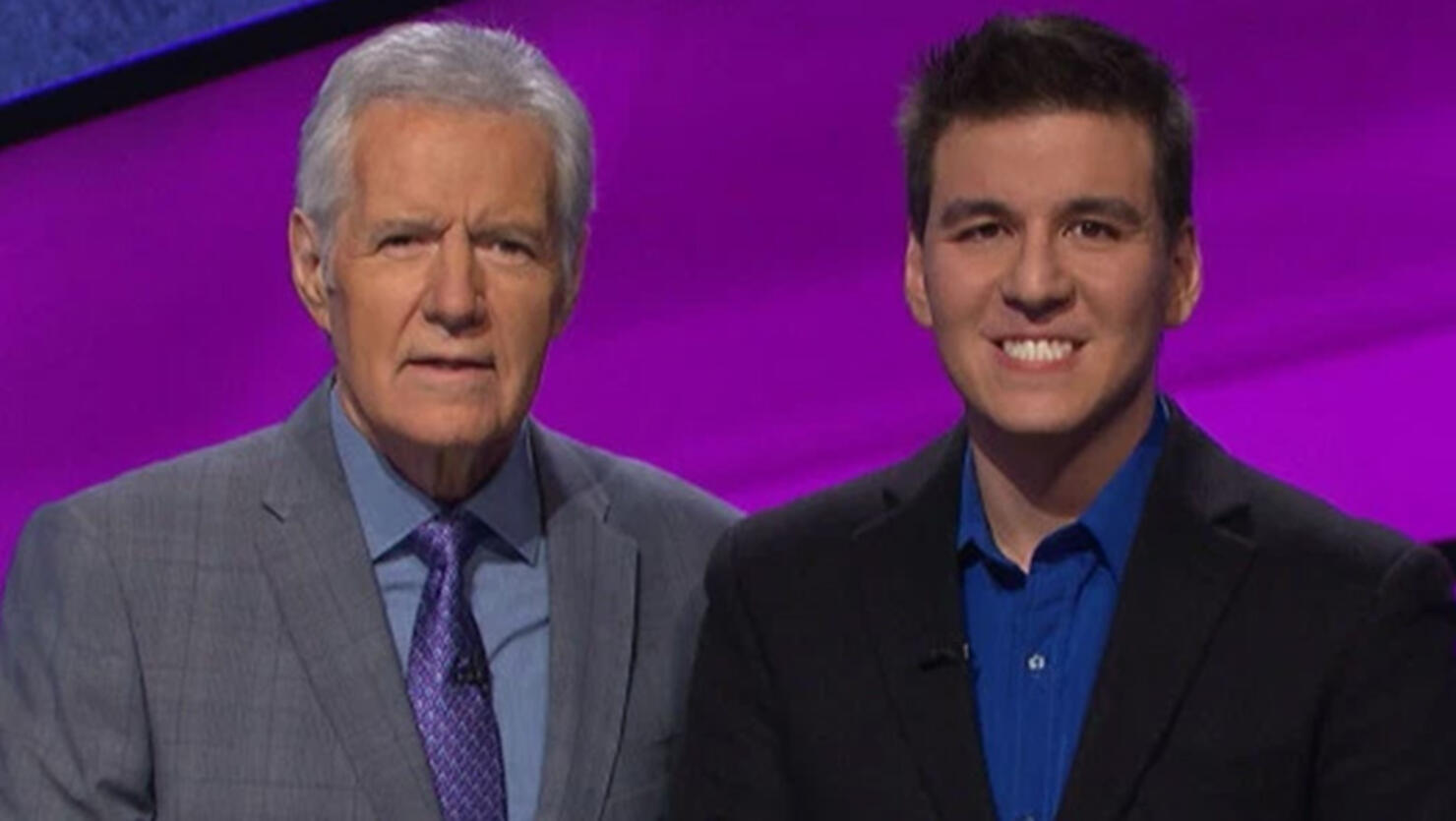 Jeopardy! host Alex Trebek standing with James Holzhauer