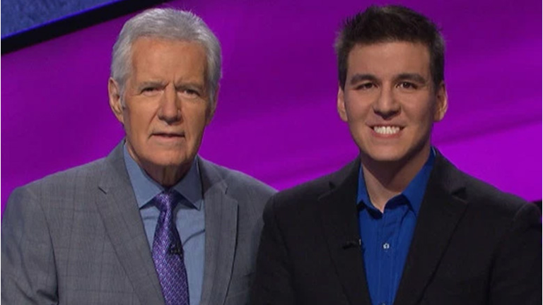 Jeopardy! host Alex Trebek standing with James Holzhauer