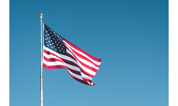 Low Angle View Of American Flag Waving Against Clear Blue Sky