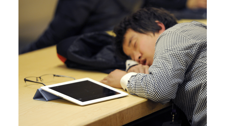 A man takes a nap next to his Ipad at a