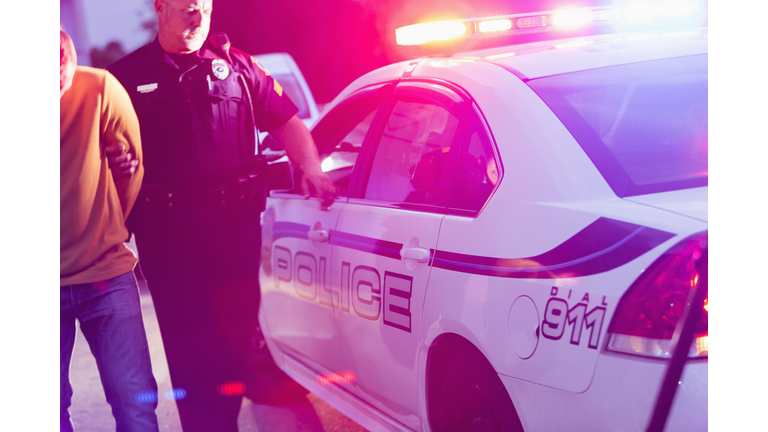 Police officer arresting a young man at night