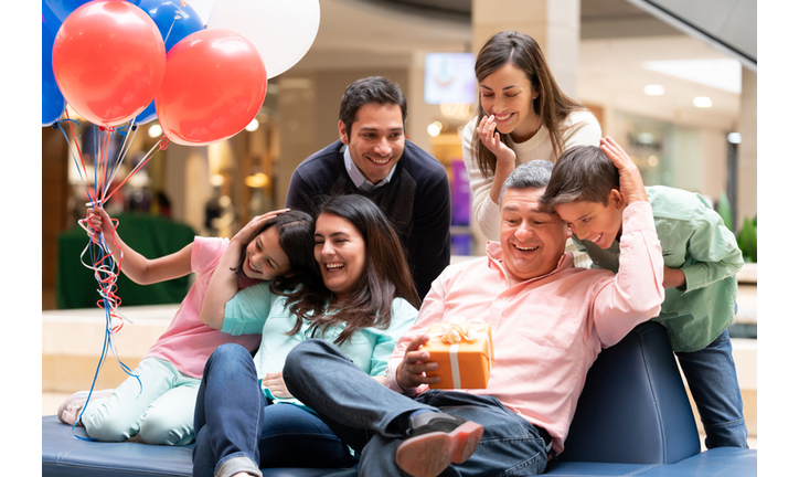 Happy grandfather celebrating Fatherâ??s Day with his family at the mall