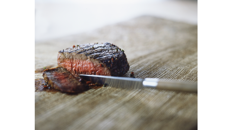 Medium rare steak with peppercorns, sliced with knife