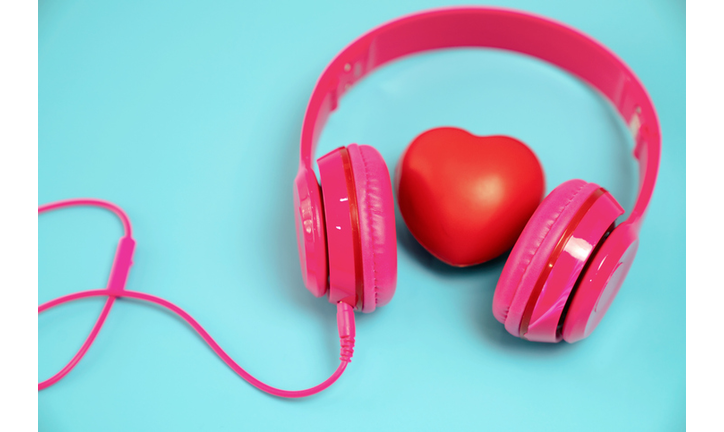 Red heart with headphones on blue background.