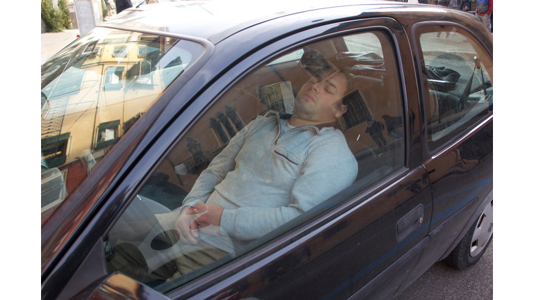 Man Sleeping In Car Seen Through Window