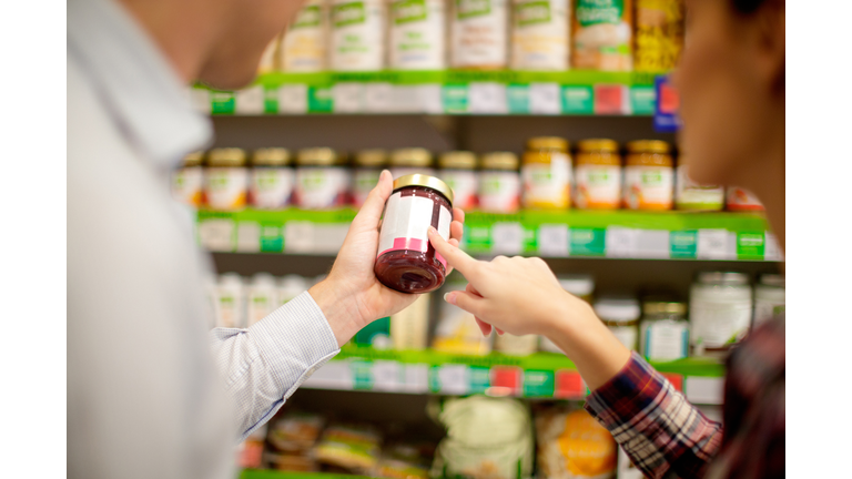 Couple choosing jar of jam