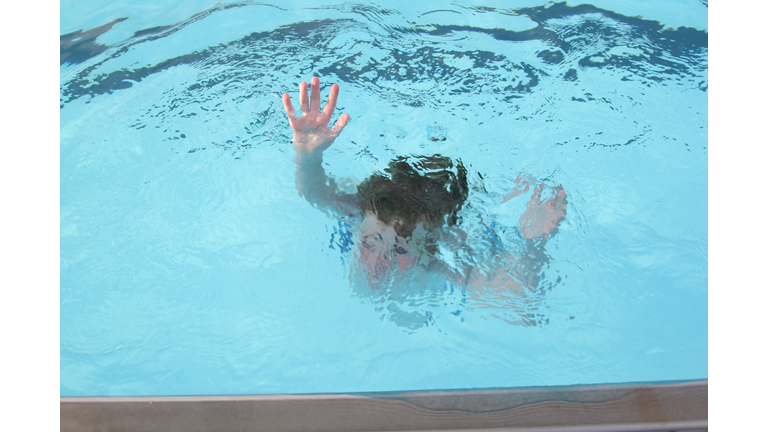 A person sinking in a swimming pool 