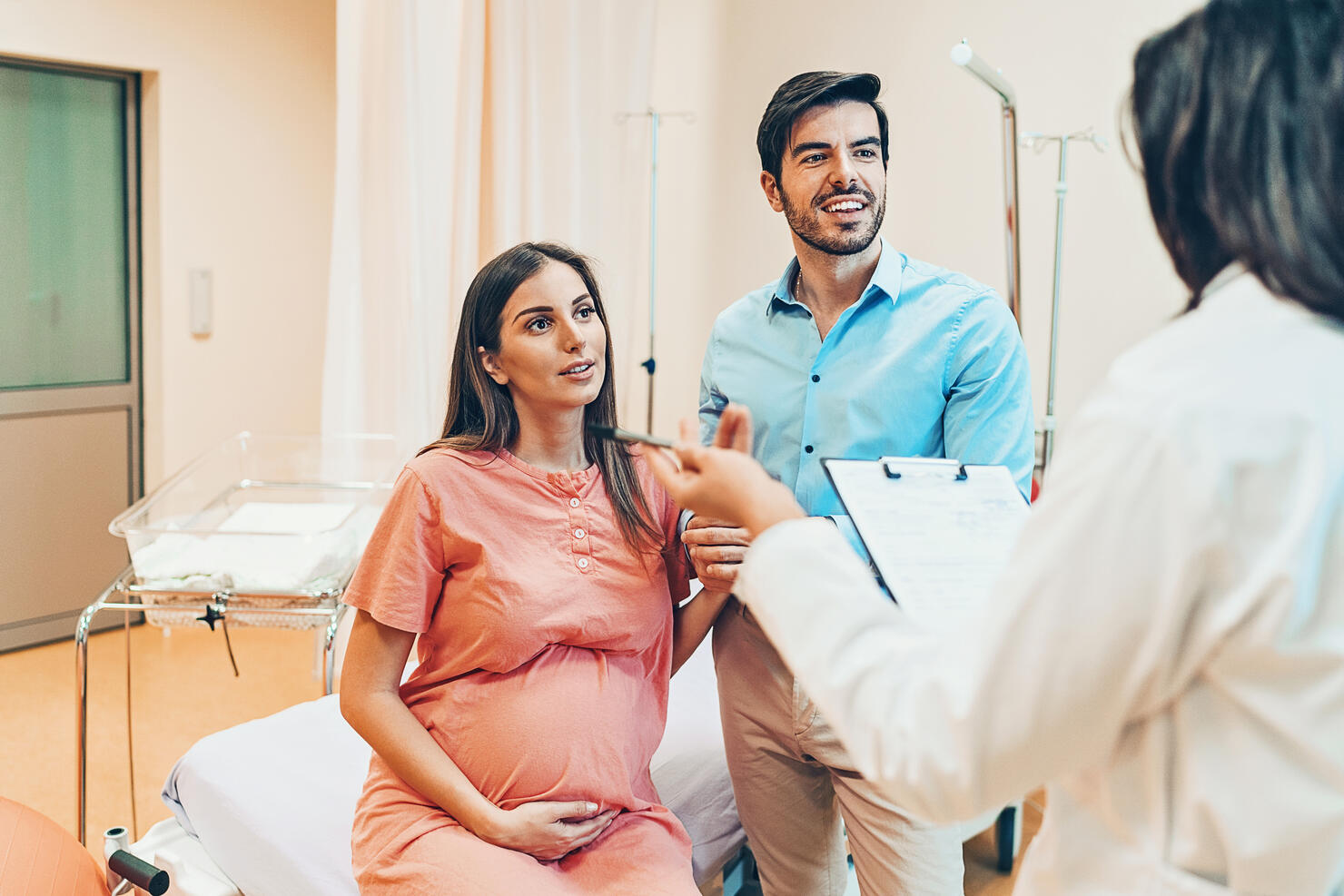 Husband and wife talking to the doctor in the hospital