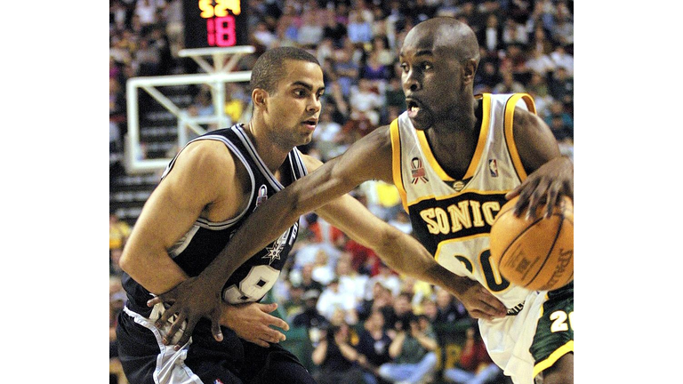 Seattle Supersonic Gary Payton (R) drives past San