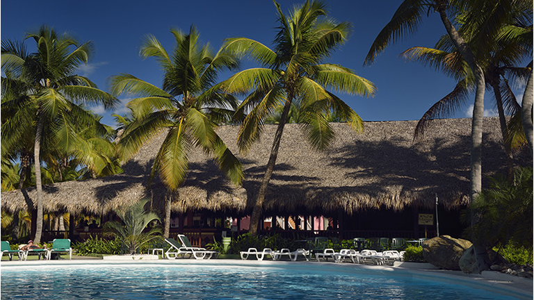 Pool and bar with coconut palm trees in Puerto Plata Dominican Republic