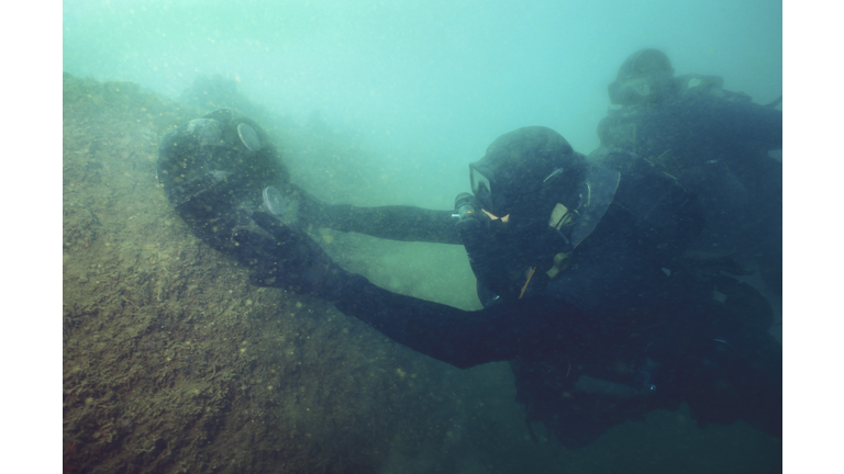 U.S. Navy SEAL combat swimmers place a MK-1 Limpet mine onto a target.