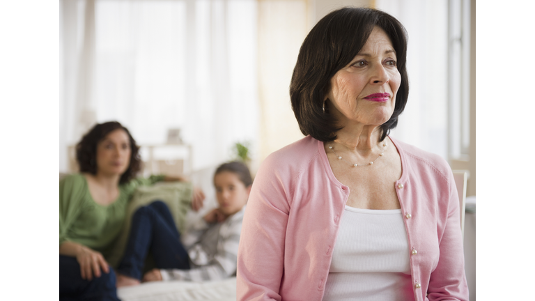 Serious woman with family in background