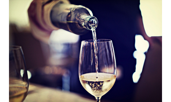 Midsection Of Waiter Pouring Wine In Glass At Restaurant