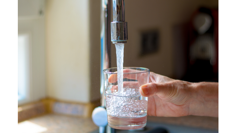 Woman filling a glass of water from a tap