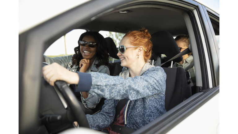 Smiling young women friends in car, enjoying road trip