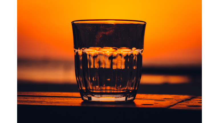 Empty drinking glass against sunset