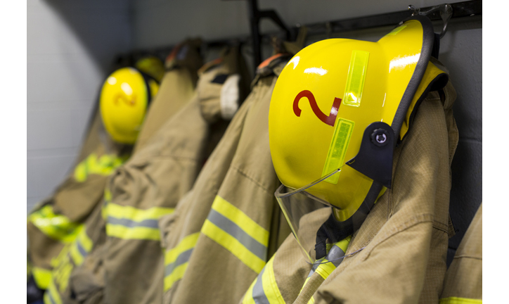 Coats and helmets of fire fighters hanging on hooks